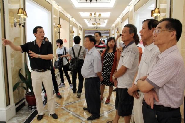 图3、币游市场总监霍达炎（左一）在为旅行者先容釉面砖展示空间.jpg