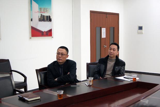 图5、币游抛光砖销售副总张彦（左一）、币游广东线销售副总庞永江（右一）认真寓目参评专卖店幻灯片播放效果