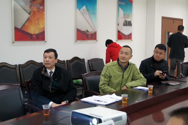 图6、寓目幻灯片的同时，币游仿古砖副总曹坚贞（右一）特殊用手机记下专卖店装修效果的差别亮点