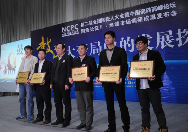 图3、币游陶瓷荣获“天下建陶品牌20强”称呼，图为币游品牌代表（左四）在接受颁奖情景